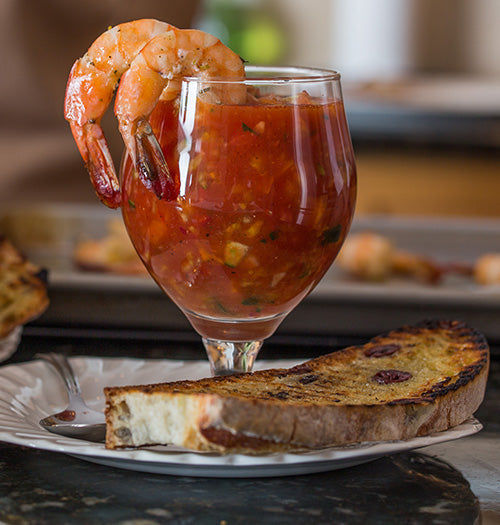 Fresh homemade Gazpacho served with shrimp on the rim of the glass, and a toasted piece of bread
