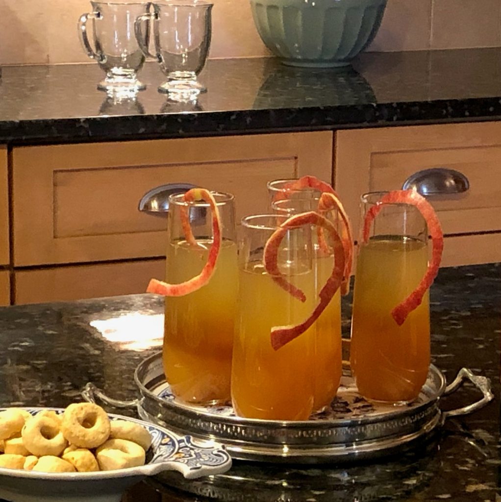 Refreshing Apple-of-My-Eye Opener cocktails made with premium Gustare Cape Cod Cranberry Pear Balsamic Vinegar, garnished with apple peels and elegantly presented on a silver tray for gourmet entertaining