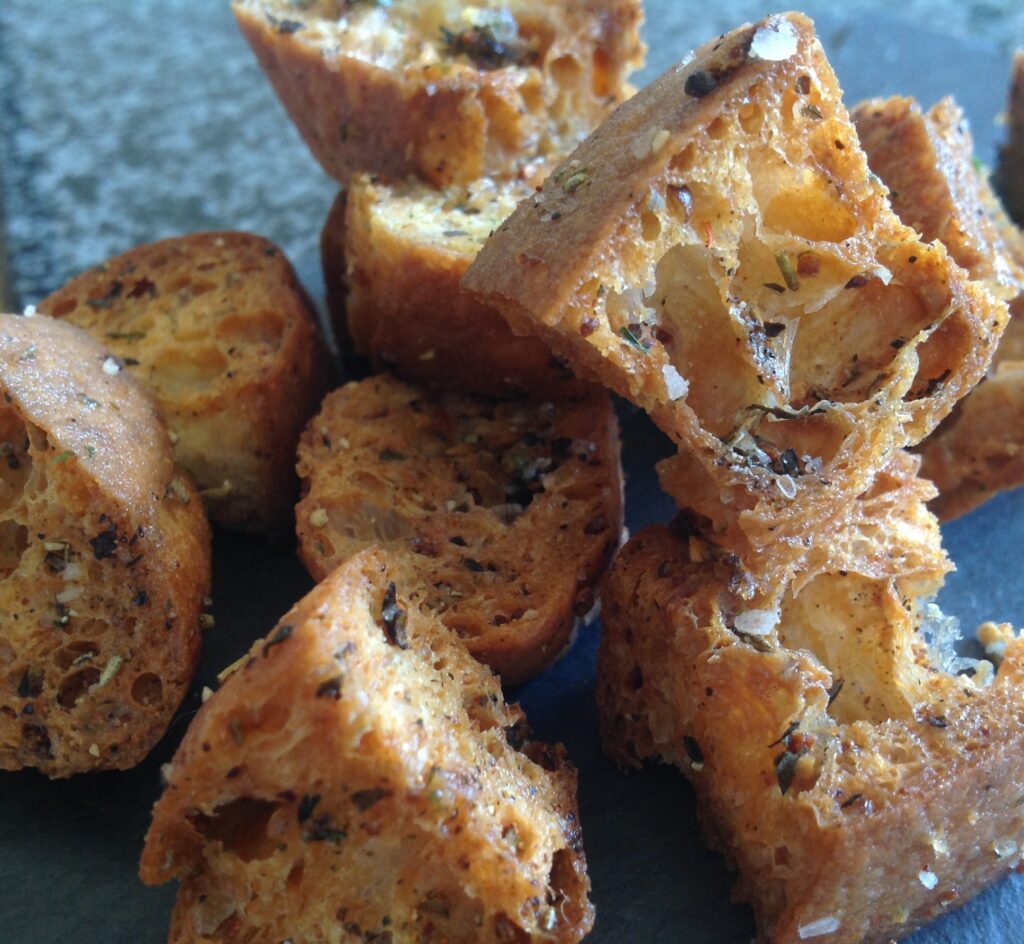 Crispy golden homemade seasoned croutons made with Gustare Coratina Extra Virgin Olive Oil and Tuscan Blend Seasoning