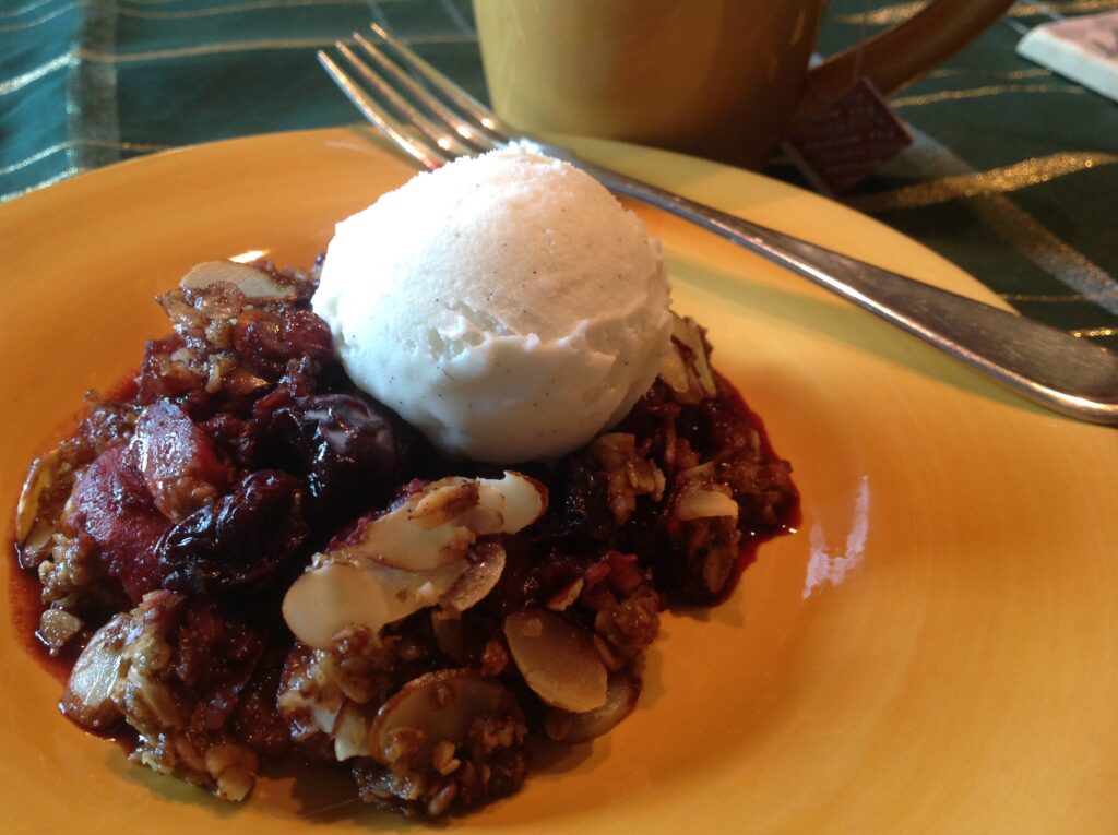 Gluten free pear cherry crumble topped with vanilla bean ice cream, made with Gustare Gourmet's premium Blood Orange Olive Oil and Cinnamon Pear Balsamic Vinegar