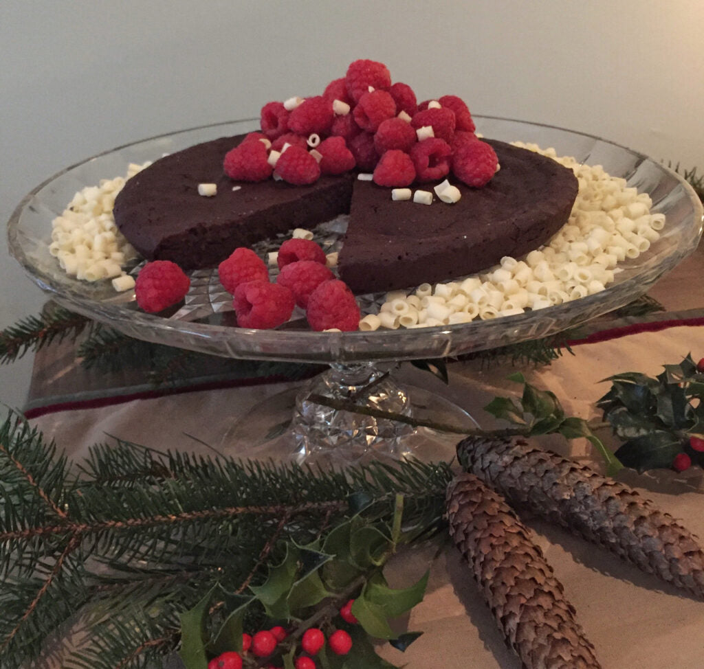 Decadent gluten free chocolate cake showcasing Gustare Gourmet blood orange extra virgin olive oil and espresso balsamic. Rich dessert with premium ingredients.