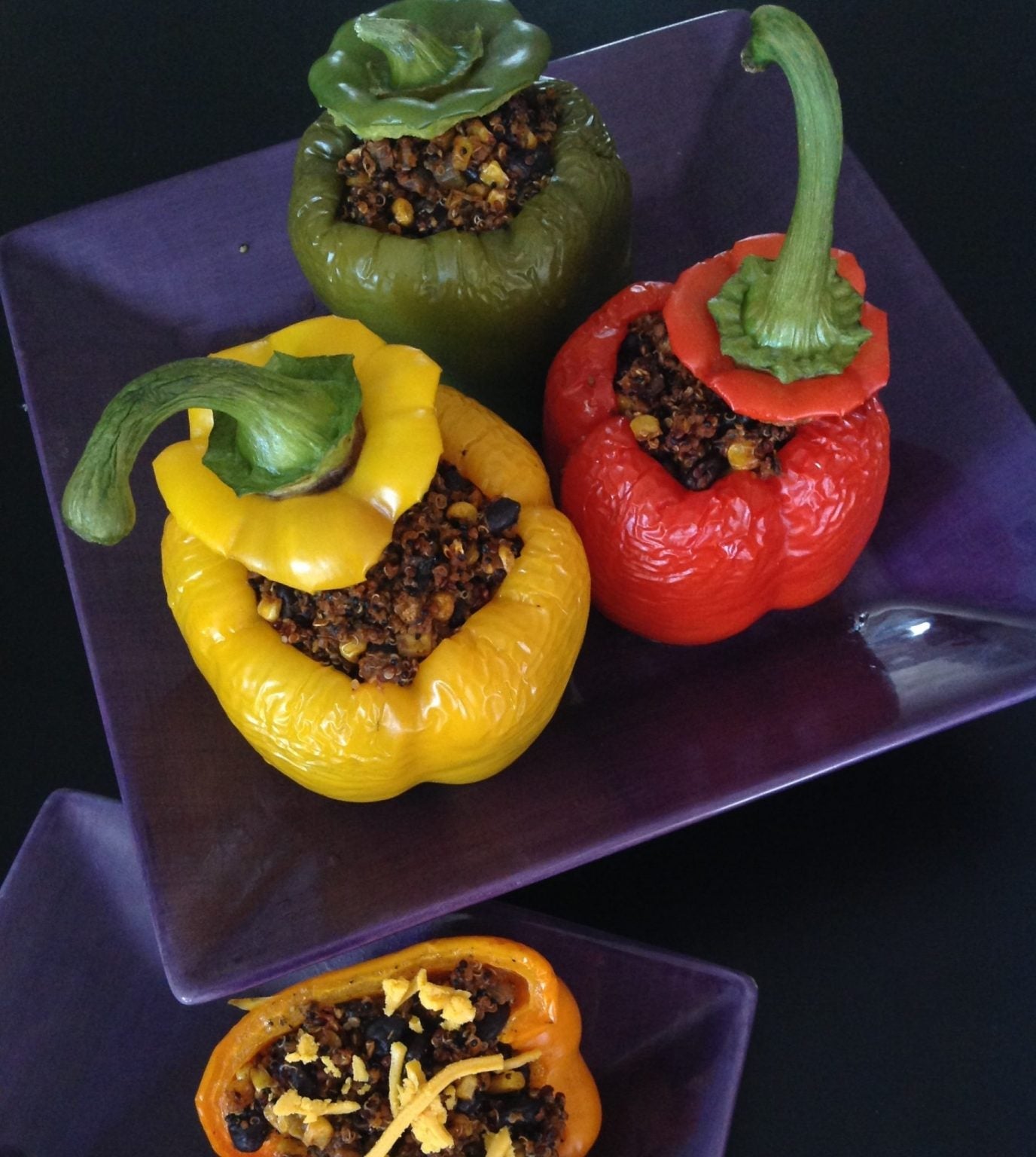 Colorful southwestern stuffed bell peppers filled with quinoa, black beans, and corn, roasted with Gustare Pepperoncino Garlic Olive Oil
