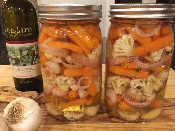 Two mason jars packed with spicy pickled winter vegetables brined with Gustare Santorini Oregano Balsamic Vinegar, showcasing how premium artisan vinegars transform everyday ingredients into gourmet condiments