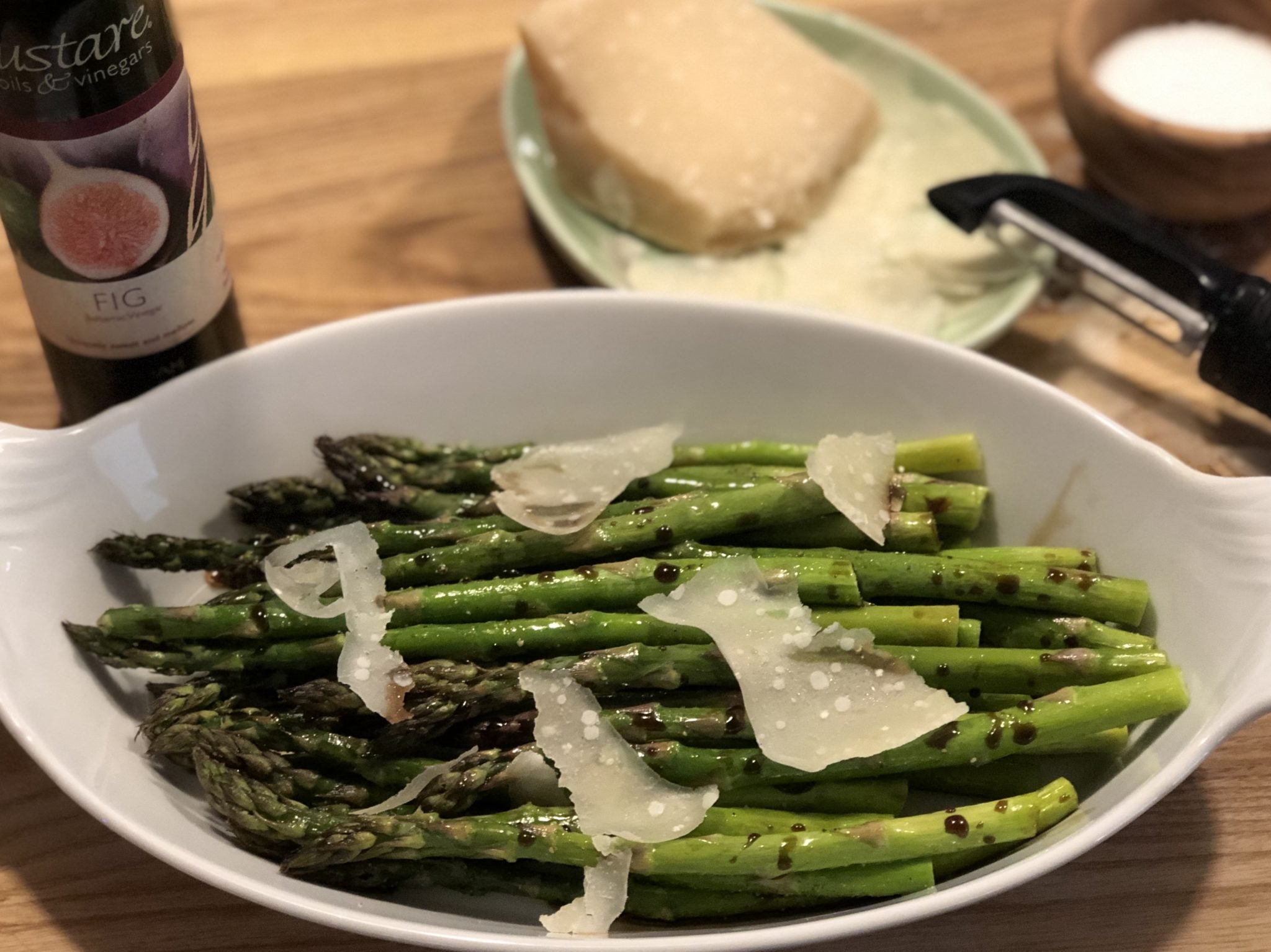 Tender roasted asparagus drizzled with Gustare premium olive oil and fig balsamic vinegar, garnished with fresh Parmigiano-Reggiano shavings, showcasing our gourmet Mediterranean ingredients for healthy elegant dining