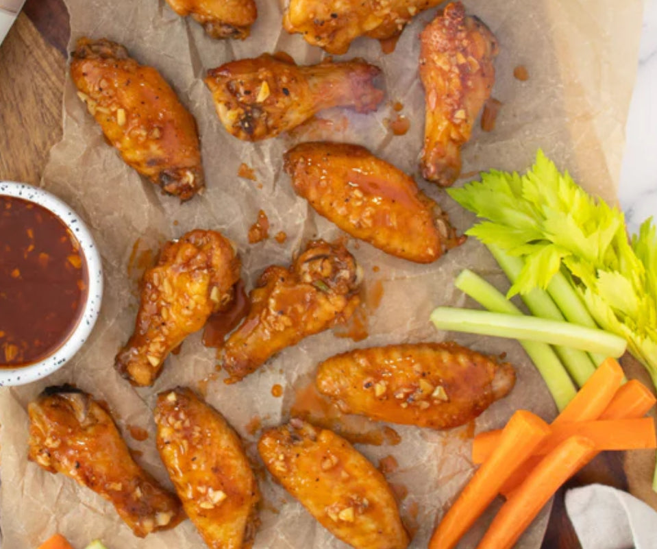 Spicy green chili garlic air fryer wings with Gustare Infused Olive Oil, celery, and carrots